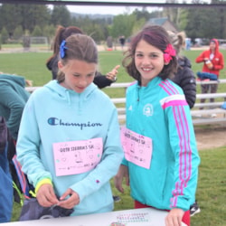 Two Girls on the Run participants smile while working with a volunteer